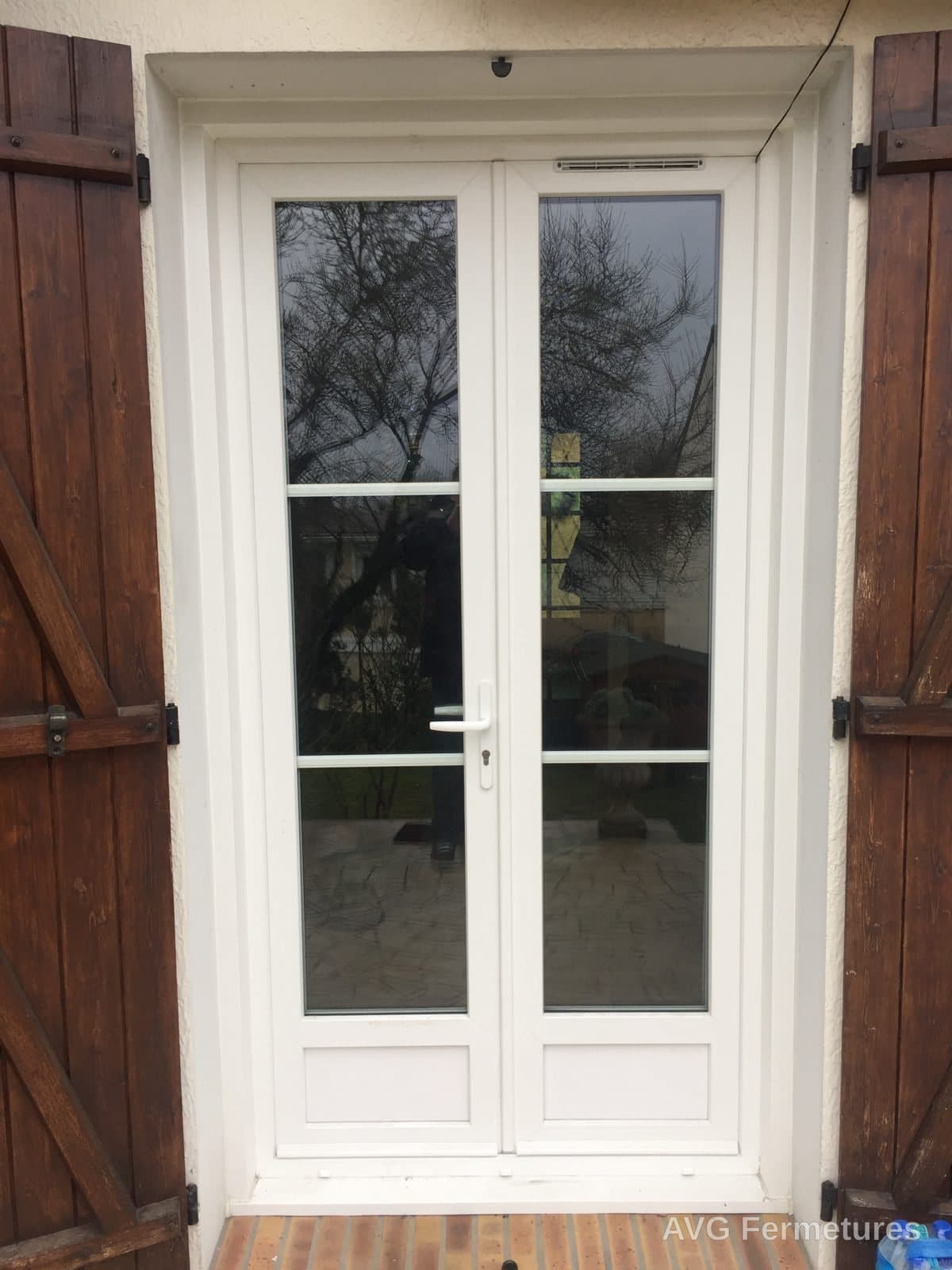 Porte-fenêtre PVC blanc conservée derrière volets bois d'origine
