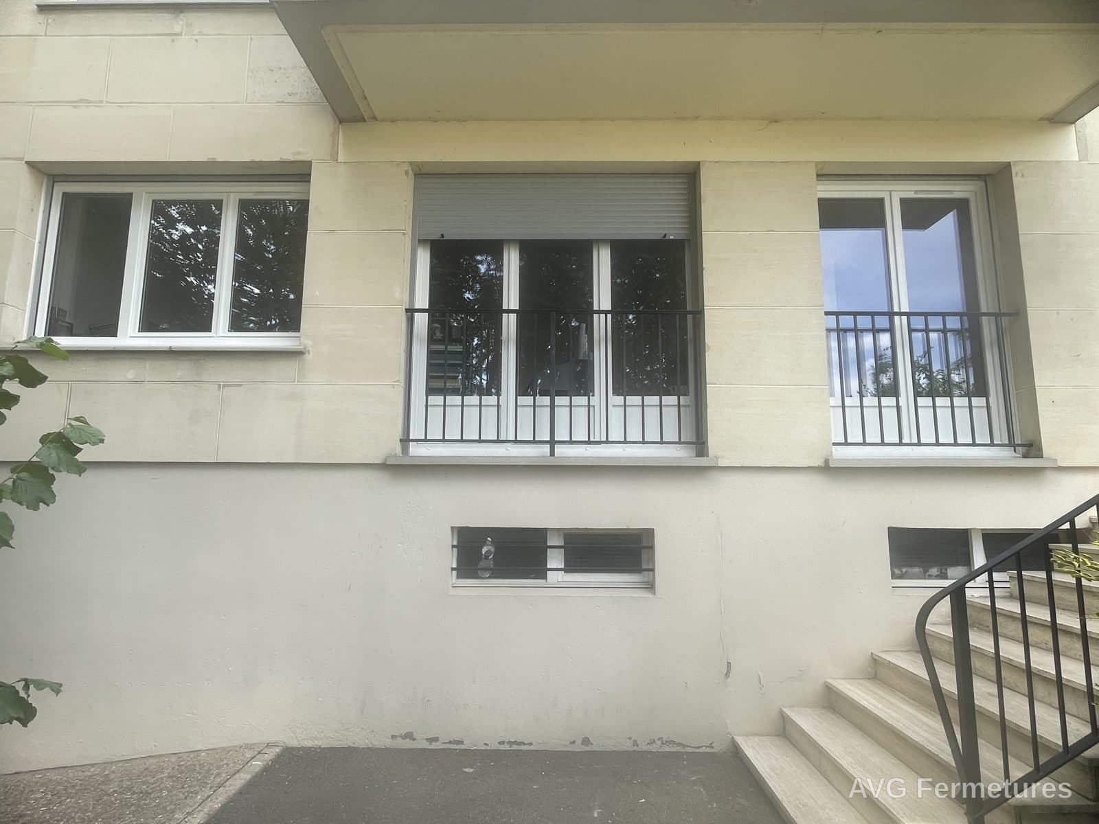 Fenêtres PVC blanches, volets roulants et garde-corps sur façade en pierre