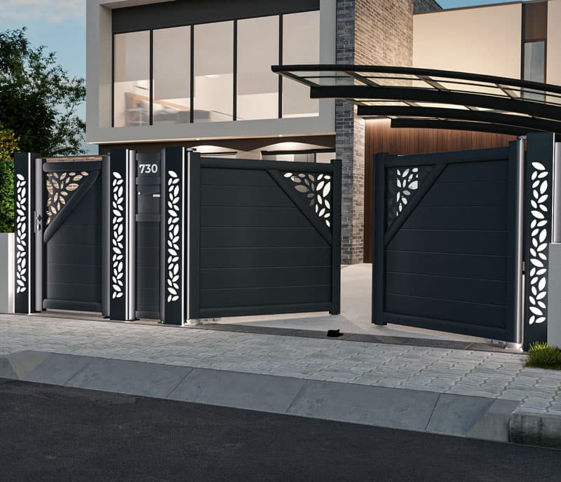 Portail battant et portillon en aluminium anthracite à panneaux décoratifs découpés devant une maison contemporaine
